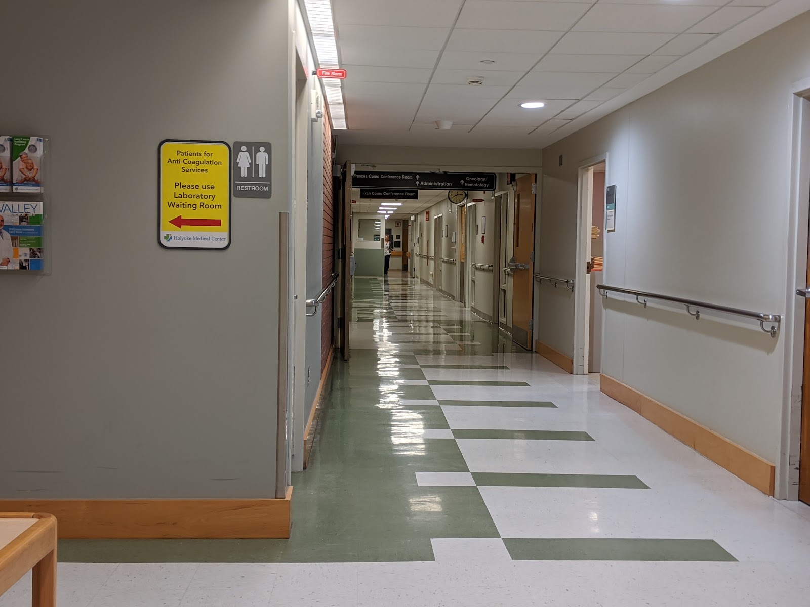 Interior medical department reception area with labeled desks for laboratory, MRI, and cardiology/neuro services