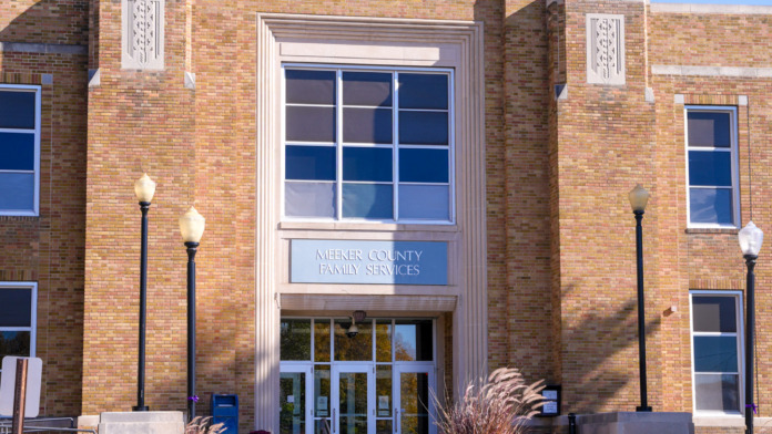 Exterior view of brick building with Litchfield signage, central entrance doors, decorative columns, and landscaped front area