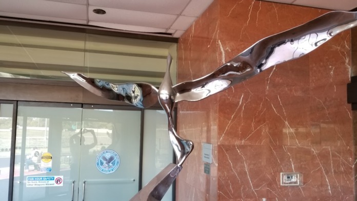 Interior lobby entrance showing Department of Veterans Affairs seal on door with red marble walls and contemporary decor