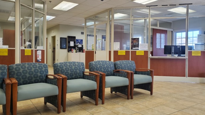 Interior lobby with comfortable seating chairs, tiled flooring, glass partition walls, and information displays