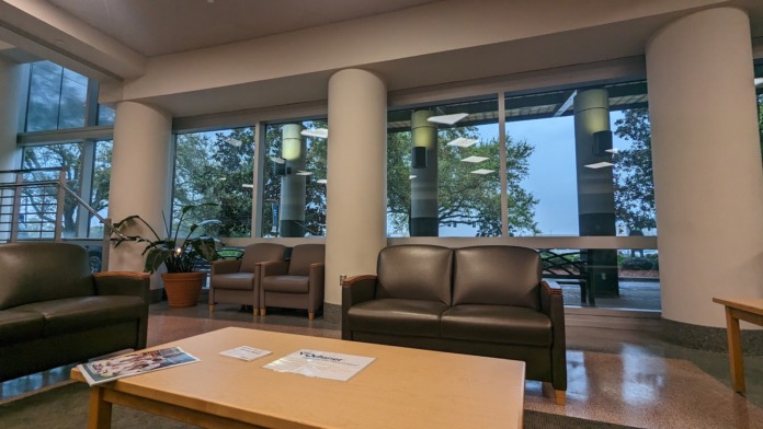 Interior patient lounge with leather seating, modern furniture, large windows, river views, and natural light