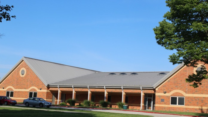Exterior of brick treatment facility showing main entrance with covered portico and landscaping