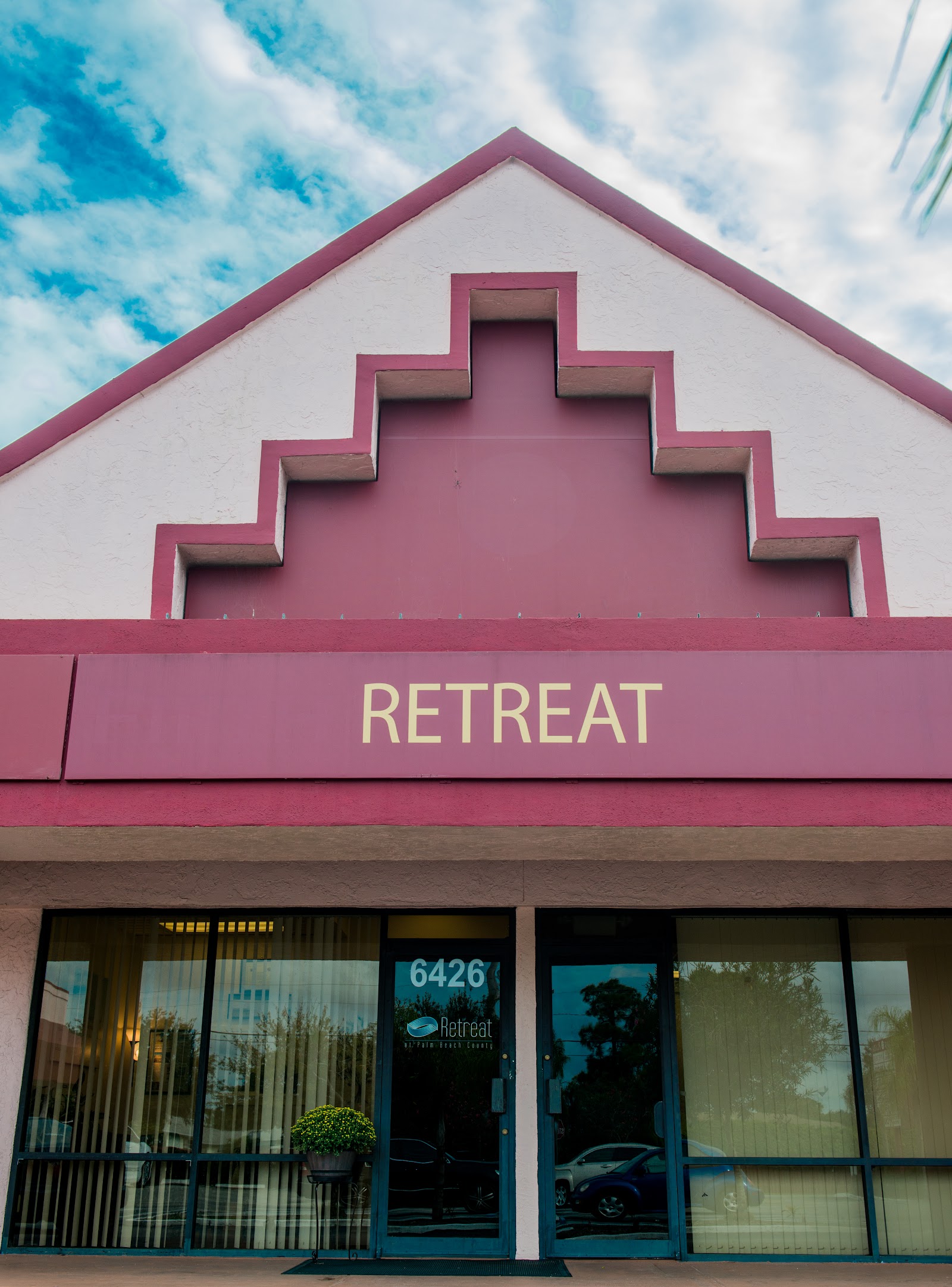 Exterior view of Retreat Behavioral and Mental Health Center showing distinctive pink and white architectural facade with facility signage and entrance doors