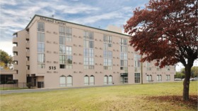 Exterior view of McLeod Center multi-story brick building with address 515, landscaped grounds, and parking area
