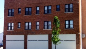 Exterior view of red brick treatment facility building with multiple windows and white garage doors