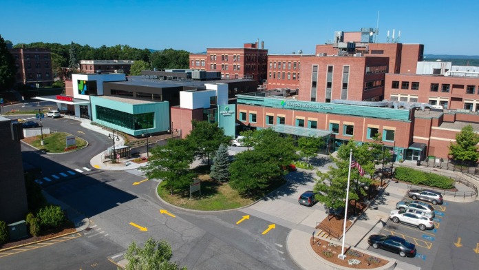 Exterior aerial view of Holyoke Medical Center showing modern turquoise and brick buildings, parking areas, and landscaped grounds
