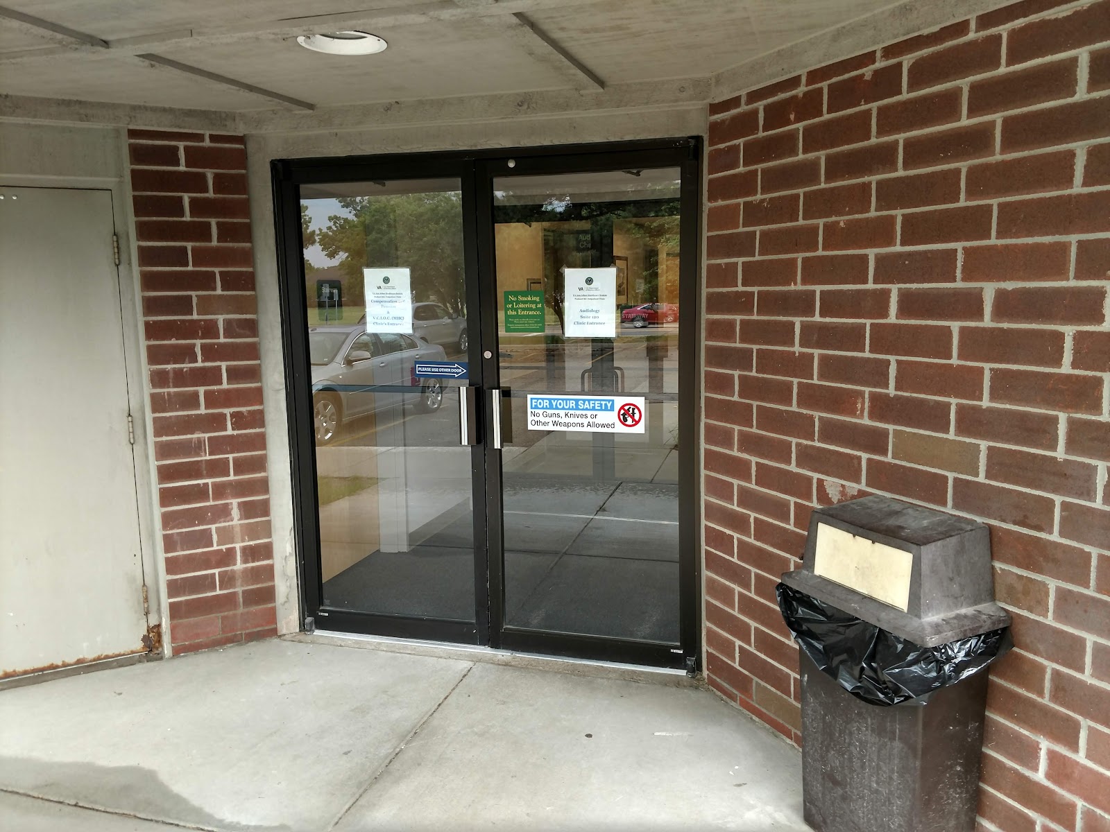 Exterior front of VA clinic building showing entrance doors, brick facade, windows, and facility identification signage