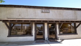 Exterior view of Pine Ridge Treatment Centers entrance with signage, large windows, and covered entry area