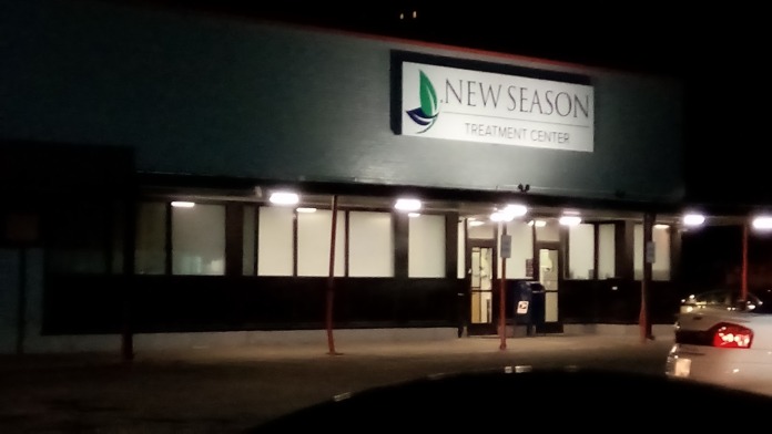 Exterior night view of New Season Treatment Center main entrance with illuminated signage and glass storefront