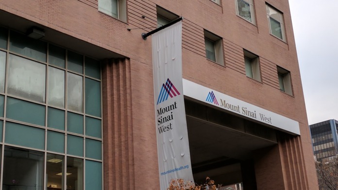 Exterior view of Mount Sinai West building entrance with white signage and brown brick facade