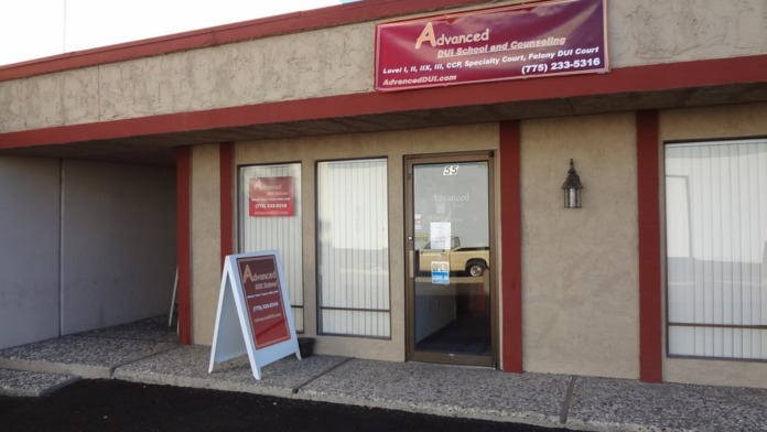 Exterior view of treatment center storefront with glass entrance door, windows, red trim, and facility signage