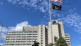 Exterior view of multi-story VA Medical Center building with flags and main entrance area