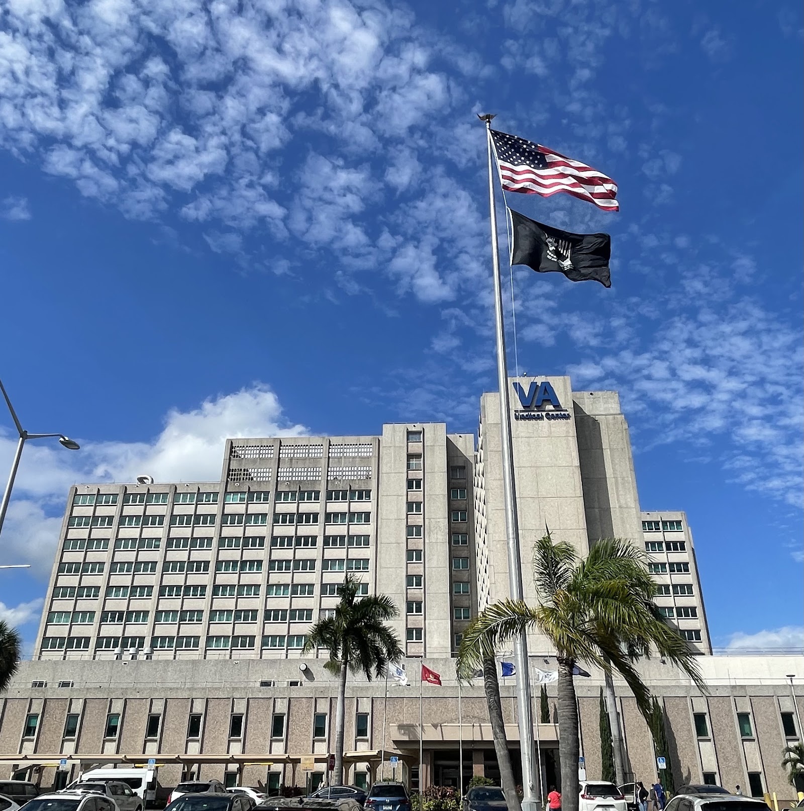 Exterior view of multi-story VA Medical Center building with flags and main entrance area