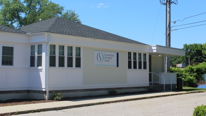 Exterior front view of white treatment center building with Cornell Scott Hill Health Center signage and main entrance