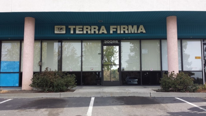 Exterior front view of Terra Firma Diversion facility showing main entrance with large signage, glass doors, landscaping, and parking area