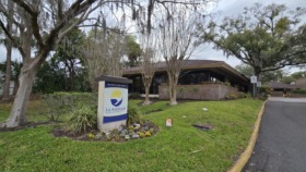Exterior view of La Amistad Behavioral Health Services building with entrance sign, mature landscaping, and brick facade
