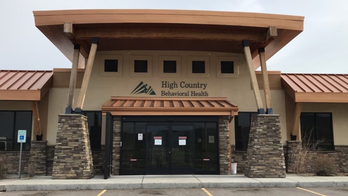 Exterior view of treatment facility main entrance with stone pillars, glass doors, and facility signage
