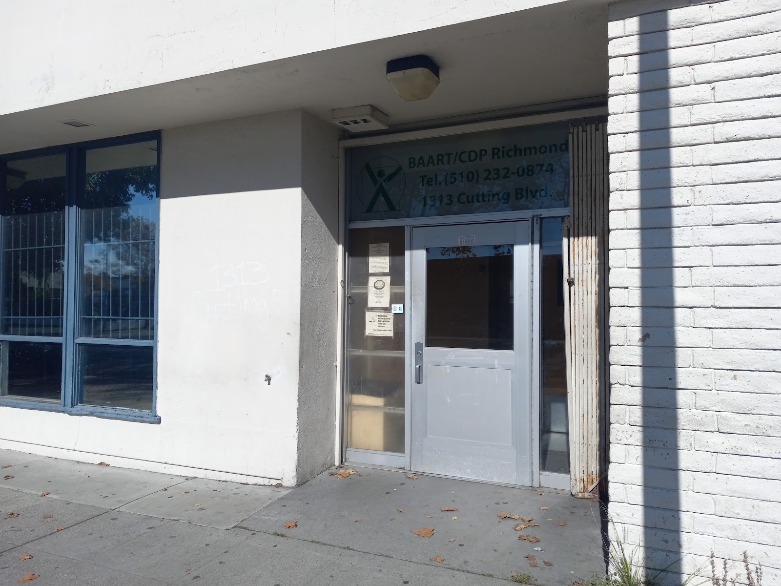 Exterior view of treatment facility entrance with white and brick facade, glass doors, and signage