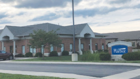 Exterior view of Harbor treatment facility brick building with main entrance, landscaped grounds, and facility signage