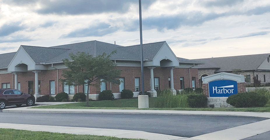 Exterior view of Harbor treatment facility brick building with main entrance, landscaped grounds, and facility signage