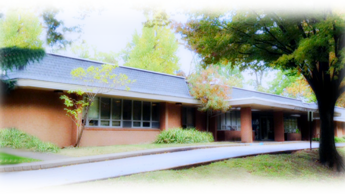 Exterior view of brick treatment center building with covered entrance, large windows, and manicured landscaping