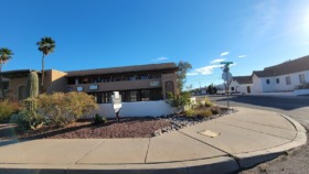 Exterior view of Next Step Counseling facility showing main entrance, desert landscaping with saguaro cactus, and parking area