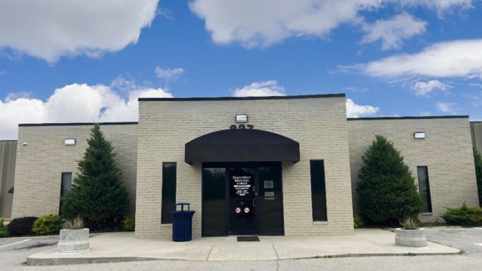 Exterior view of Ponca City Rightway Medical facility showing brick building with black awning entrance, landscaping, and parking area