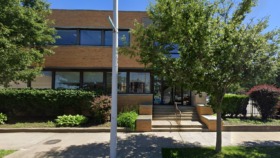 Exterior view of two-story brick treatment facility with main entrance, landscaped grounds, and large windows