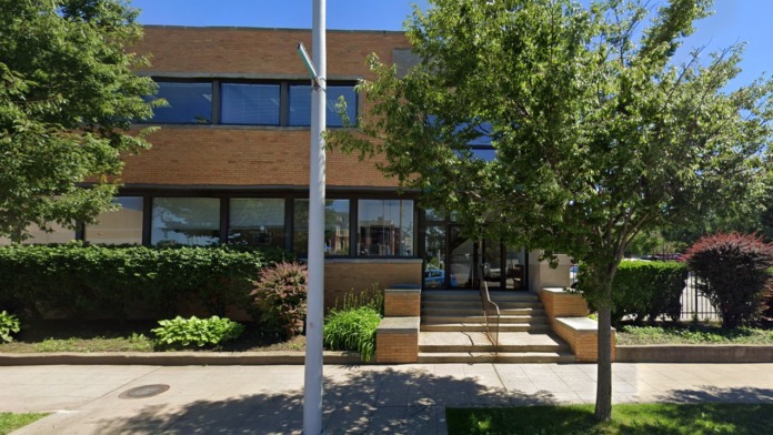 Exterior view of two-story brick treatment facility with main entrance, landscaped grounds, and large windows