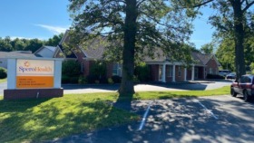 Exterior view of Spero Health Jeffersonville facility showing brick building, entrance sign, parking area, and mature trees