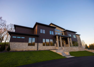 Exterior view of modern treatment center with brick and stone facade, large windows, manicured lawn, and driveway