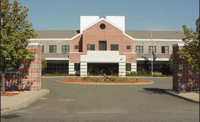 Exterior view of brick and stone treatment center building with prominent entrance, landscaped grounds, and circular driveway