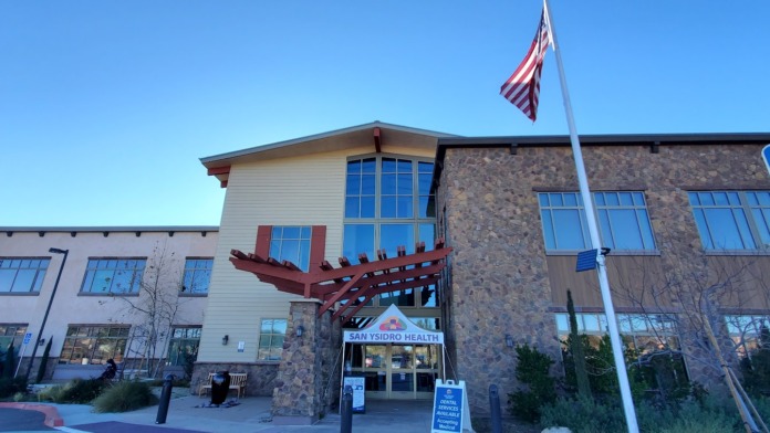Exterior front entry with stone and siding facade, covered entrance, and accessible parking area