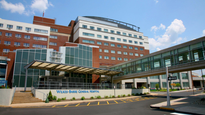 Exterior view of Wilkes-Barr General Hospital main entrance with modern glass entry, brick facade, and landscaped grounds