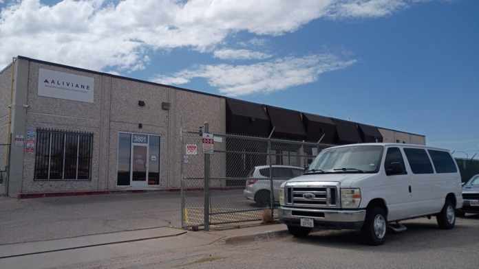 Exterior view of Aliviane Inc treatment facility showing brick facade, main entrance, and parking area with vehicles