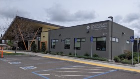 Exterior view of Communicare Health Centers Hansen Family Health Center building with parking lot, accessible parking spaces, and entrance signage