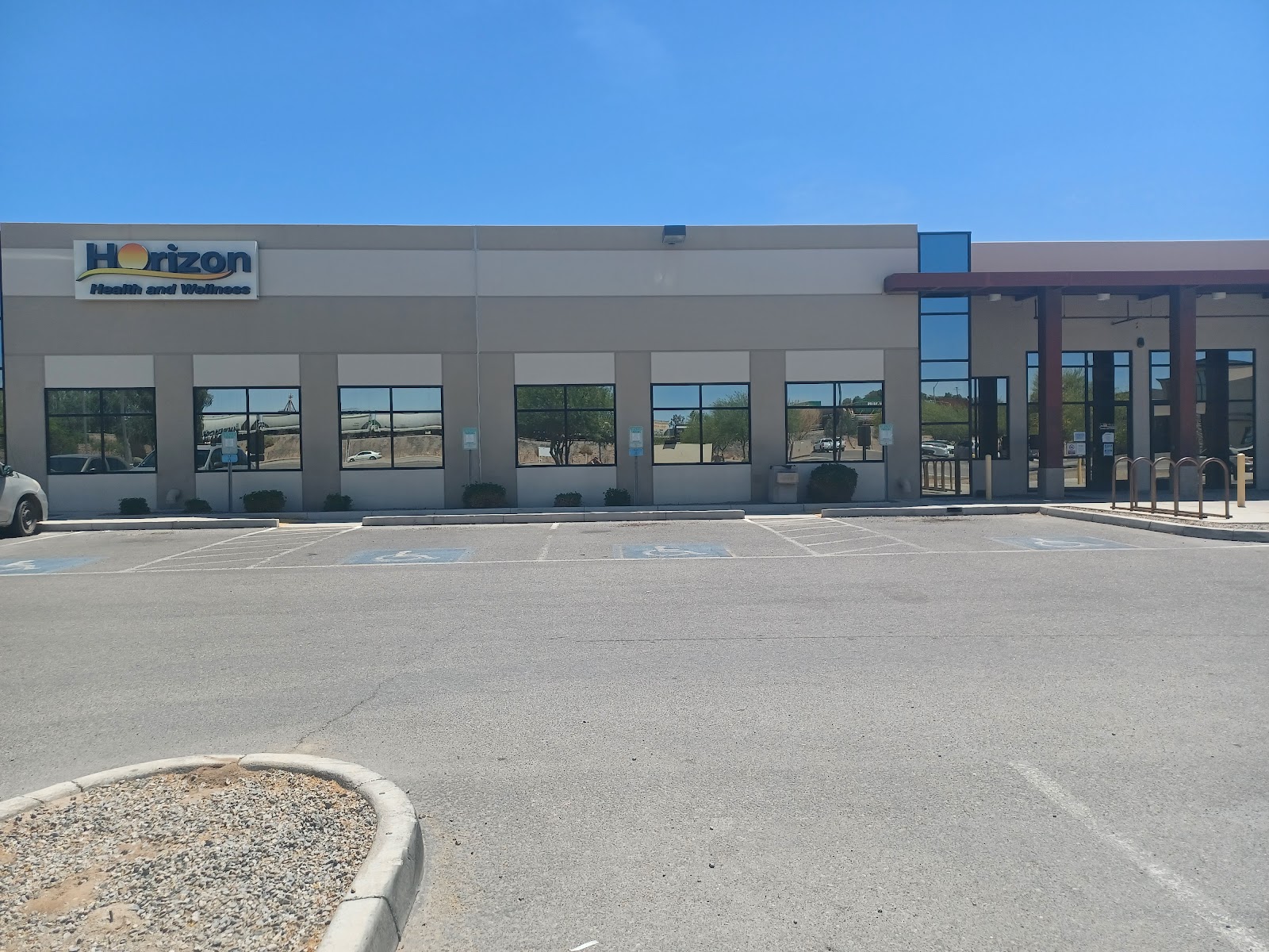 Exterior view of Horizon Health and Wellness facility showing main entrance with large windows, signage, and front parking area