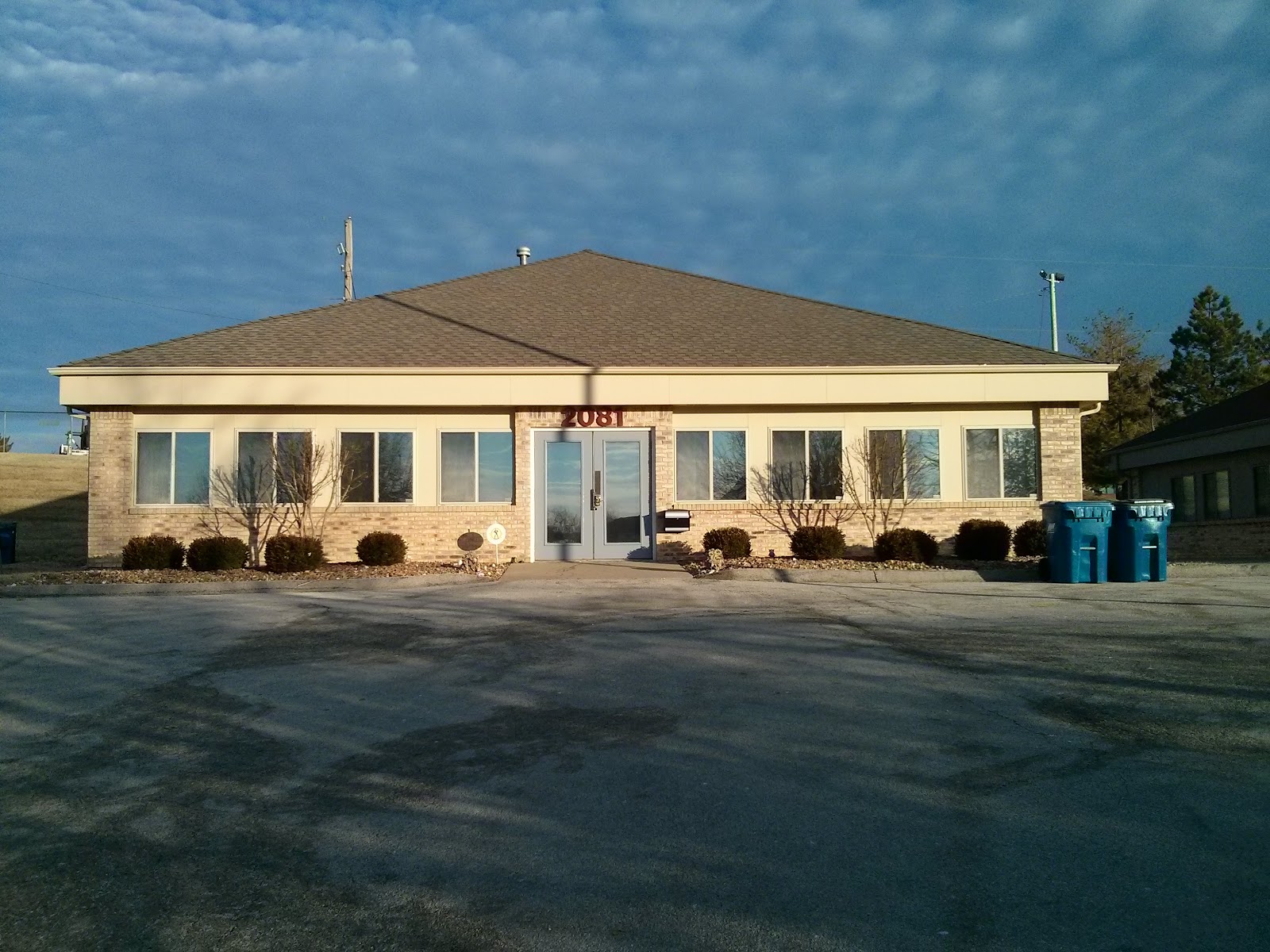 Exterior view of single-story brick counseling facility with main entrance, landscaped grounds, and parking area