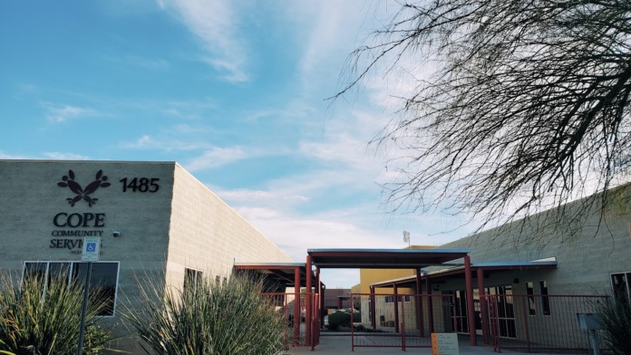 Exterior entrance of COPE community services building showing address 1485, landscaping, and covered entry structure
