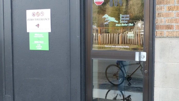 Exterior entrance door showing address 804 with welcome signage, zero tolerance policy notice, and non-smoking facility indicator