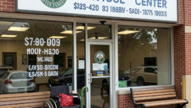Exterior view of Substance Abuse Services Center main entrance featuring brick facade, white signage, benches, and accessible entry
