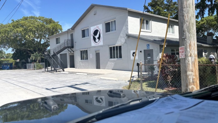 Exterior view of white two-story treatment facility building with Sonrise Mission logo sign and paved parking area