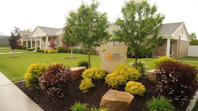 Exterior view of Steps Recovery Center building with manicured landscaping, shrubs, and stone signage
