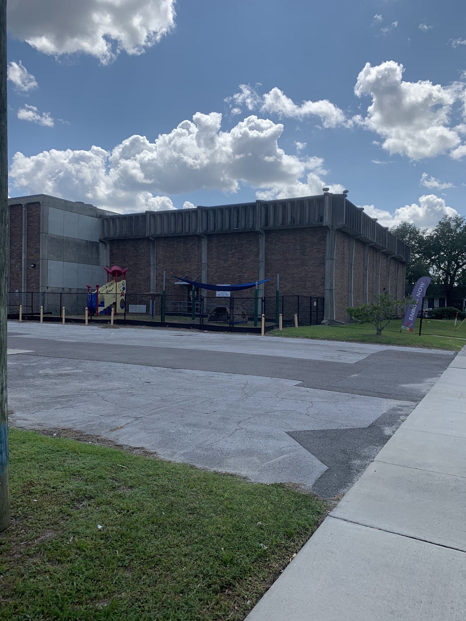 Exterior front view of treatment center with brick and concrete construction, covered entrance area, and service flag