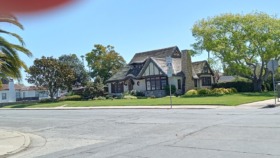 Exterior view of Tudor-style treatment facility with landscaped front lawn, street signage, and parking area
