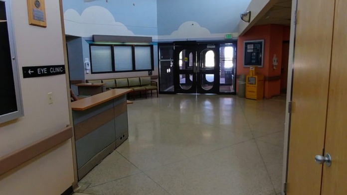 Interior lobby space with high ceilings, treatment check-in desk, waiting seating, and cloud-themed wall murals