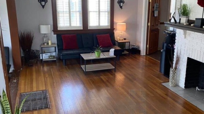 Interior lobby featuring comfortable seating with blue sofa, hardwood flooring, decorative lighting, and welcoming reception desk area