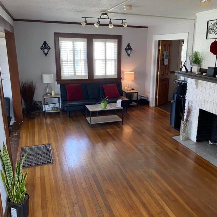 Interior lobby featuring comfortable seating with blue sofa, hardwood flooring, decorative lighting, and welcoming reception desk area