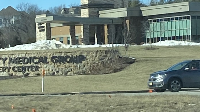 Exterior contemporary medical facility with stone signage and multi-section modern architecture on landscaped grounds