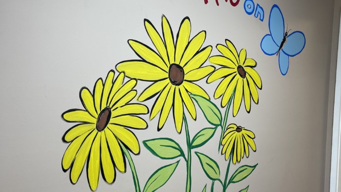 Interior wall decoration with colorful sunflower and butterfly graphics with text Put your happy on